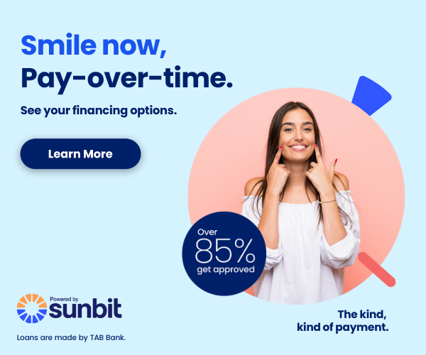 Woman smiling while holding piggy bank, dental financing promotion with 85% APR offer from Sunbit.