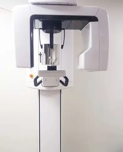 Dental imaging equipment mounted on stand in clinical setting at Riggs Family Dental office.