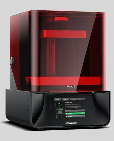Red and black 3D printer with illuminated chamber and control panel, dental laboratory equipment.