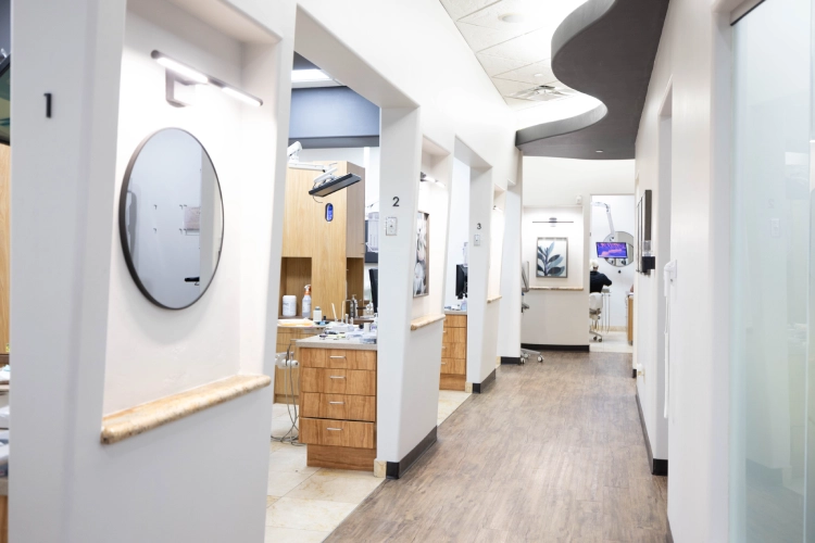 Modern dental office interior with treatment rooms, clean white walls, and professional clinical setup.