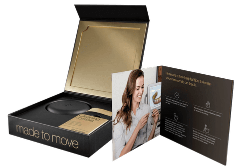 Dental practice promotional box set with product samples and informational brochures displayed.