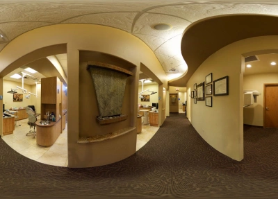 Modern dental office interior with curved hallway, warm lighting, and multiple treatment room doorways.