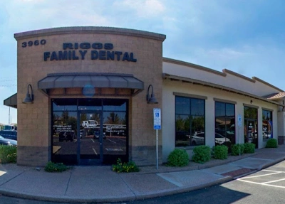 Exterior view of Riggs Family Dental brick building with storefront entrance and signage.